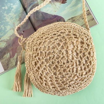 Small round handbag made of beige braided straw - Handbags
